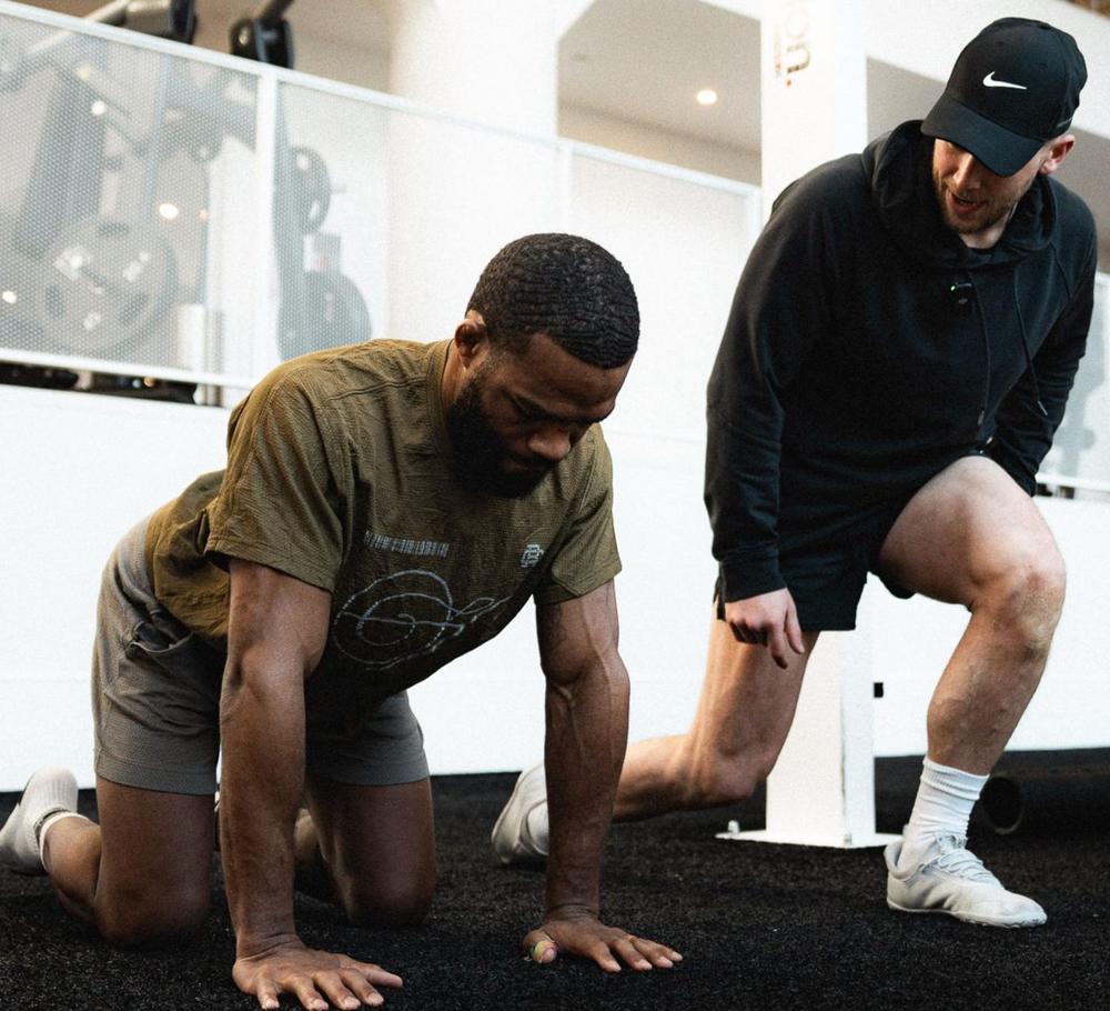 Conor coaching two clients through a mobility movement